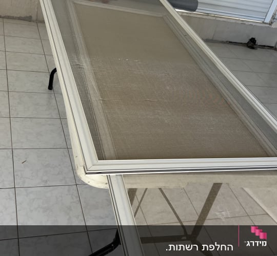 מסגרת אלומיניום עם רשת על שולחן